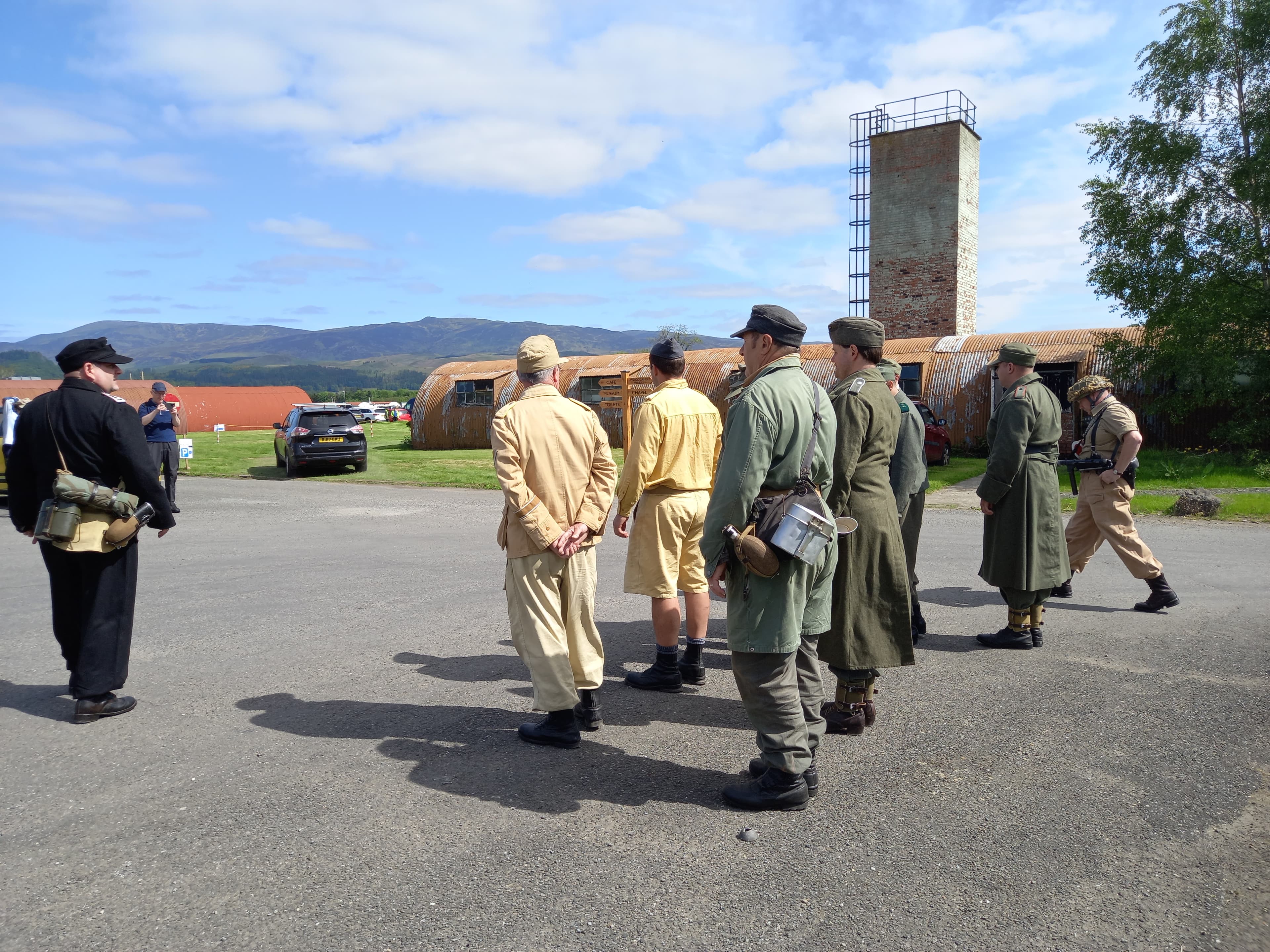 Living history participants gathered at Cultybraggan Camp with Nissen huts and hills behind them